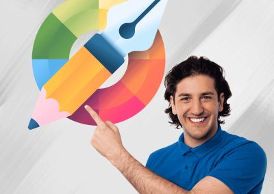 Un hombre de tez clara y cabello obscuro sonriente mientras señala una rueda de color con un lápiz y una pluma. Representa el diseño gráfico accesible.