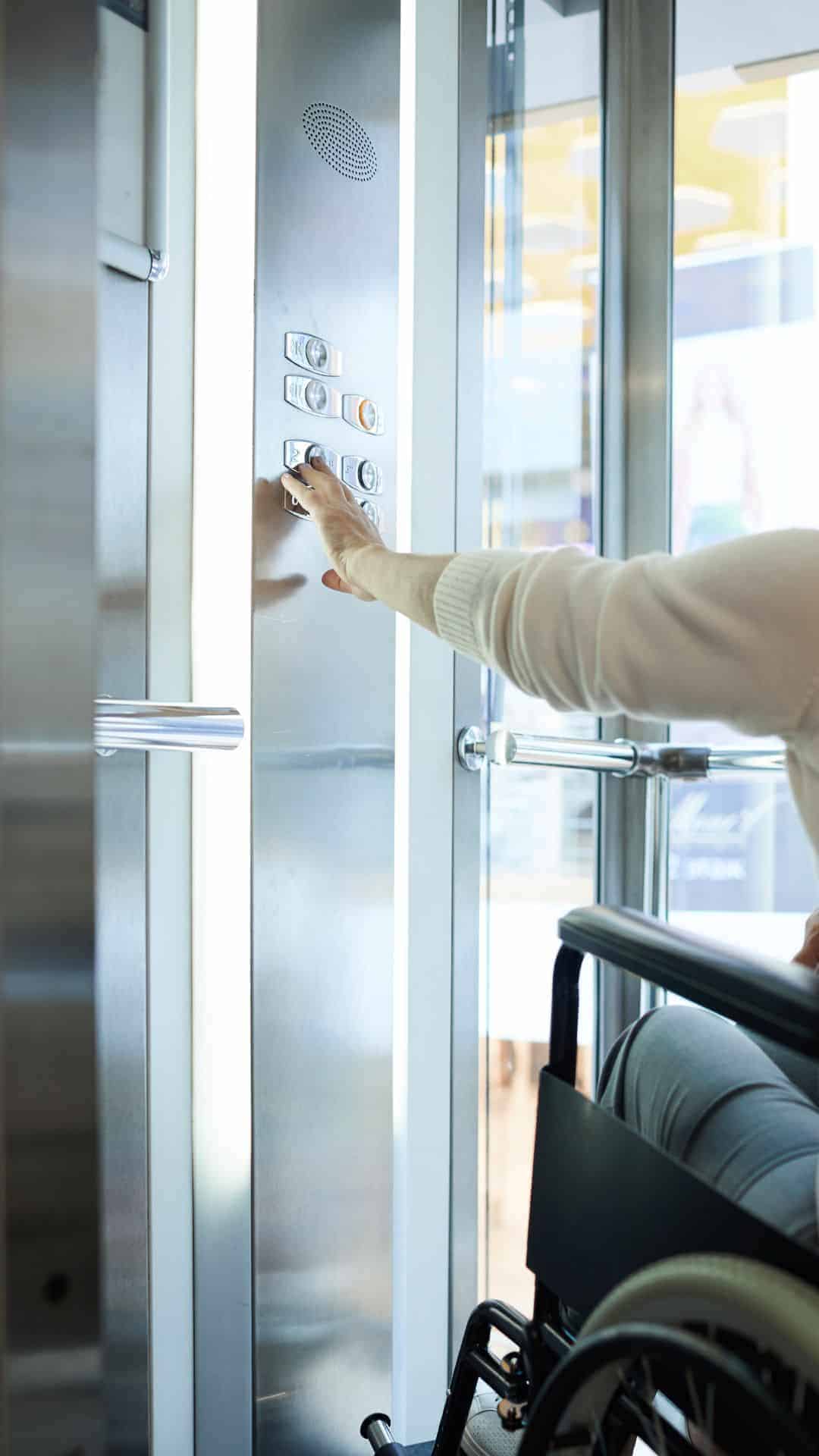Elevador accesible Uso de un elevador por una persona en silla de ruedas. Representa la tecnologia que facilita la accesibilidad y abre puertas en los entornos.